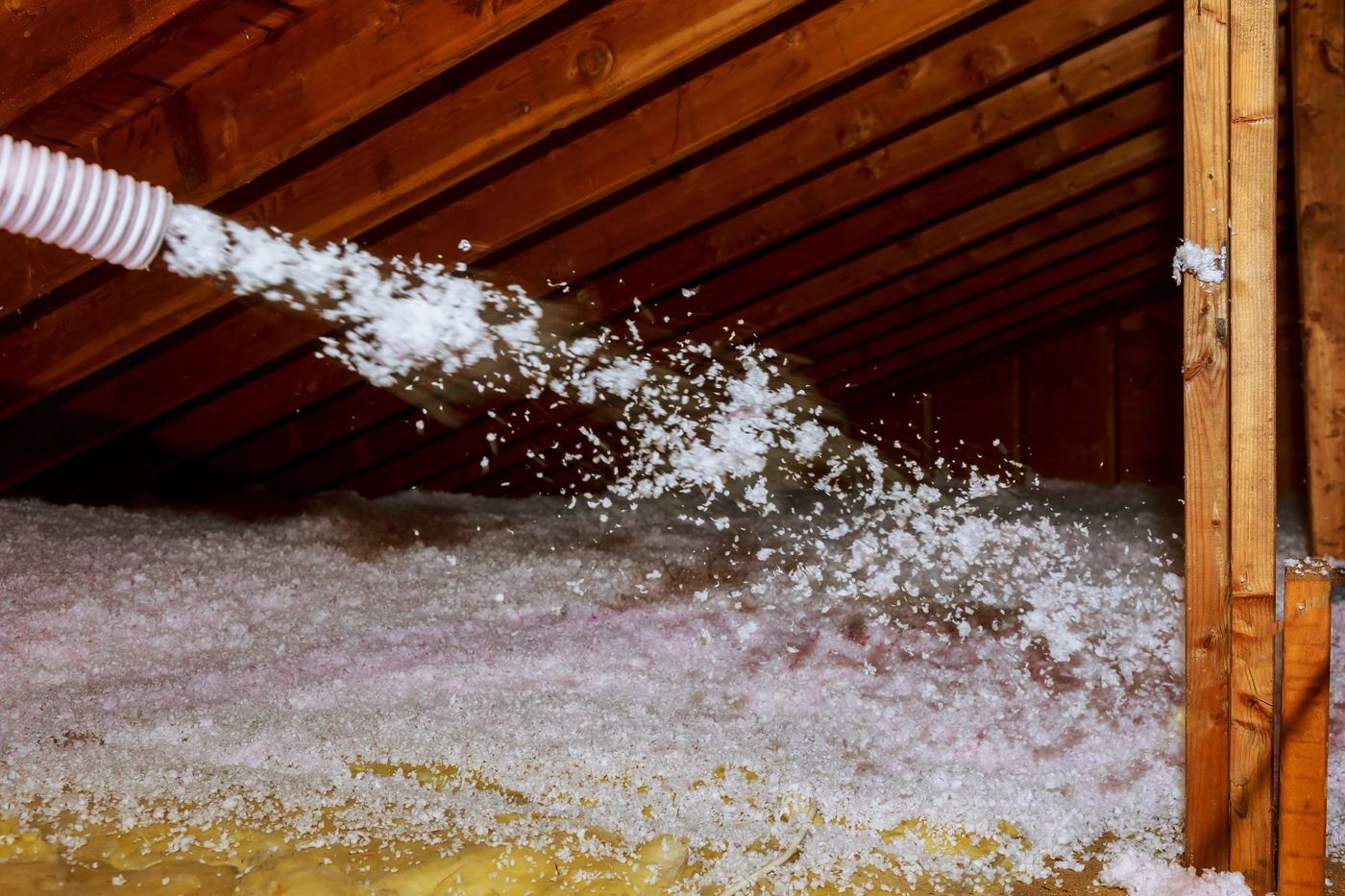 Blown-in insulation hose distributing material into a home attic